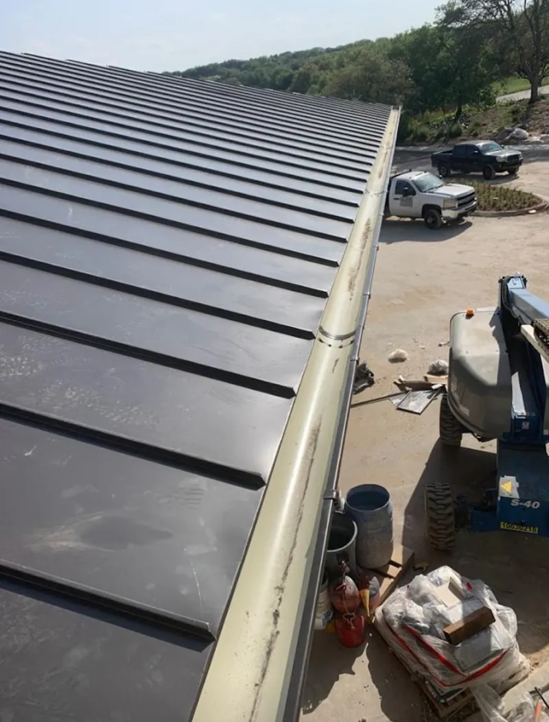 Standing seam panel and gutter detail on a metal roofing jobsite in Elm Grove